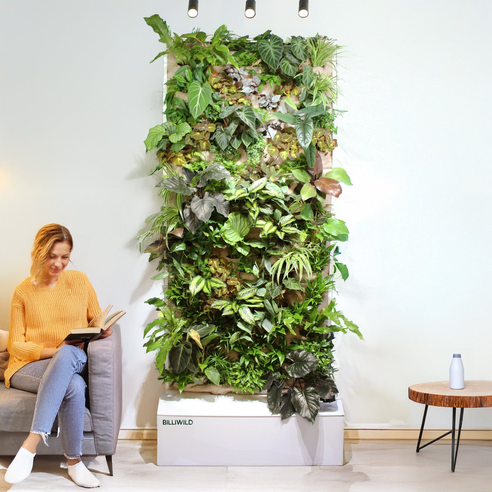 Vrouw leest naast een plantenwand